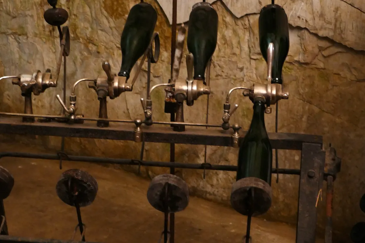 Bouteilles de champagne sur un pupitre de remuage dans une cave de craie